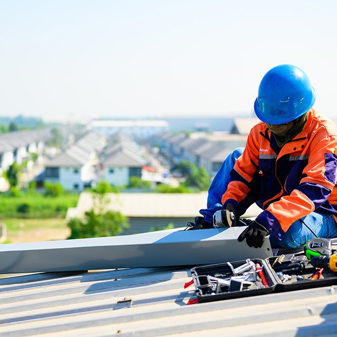 Male technician worker installing solar panels on rooftop of industrial plant